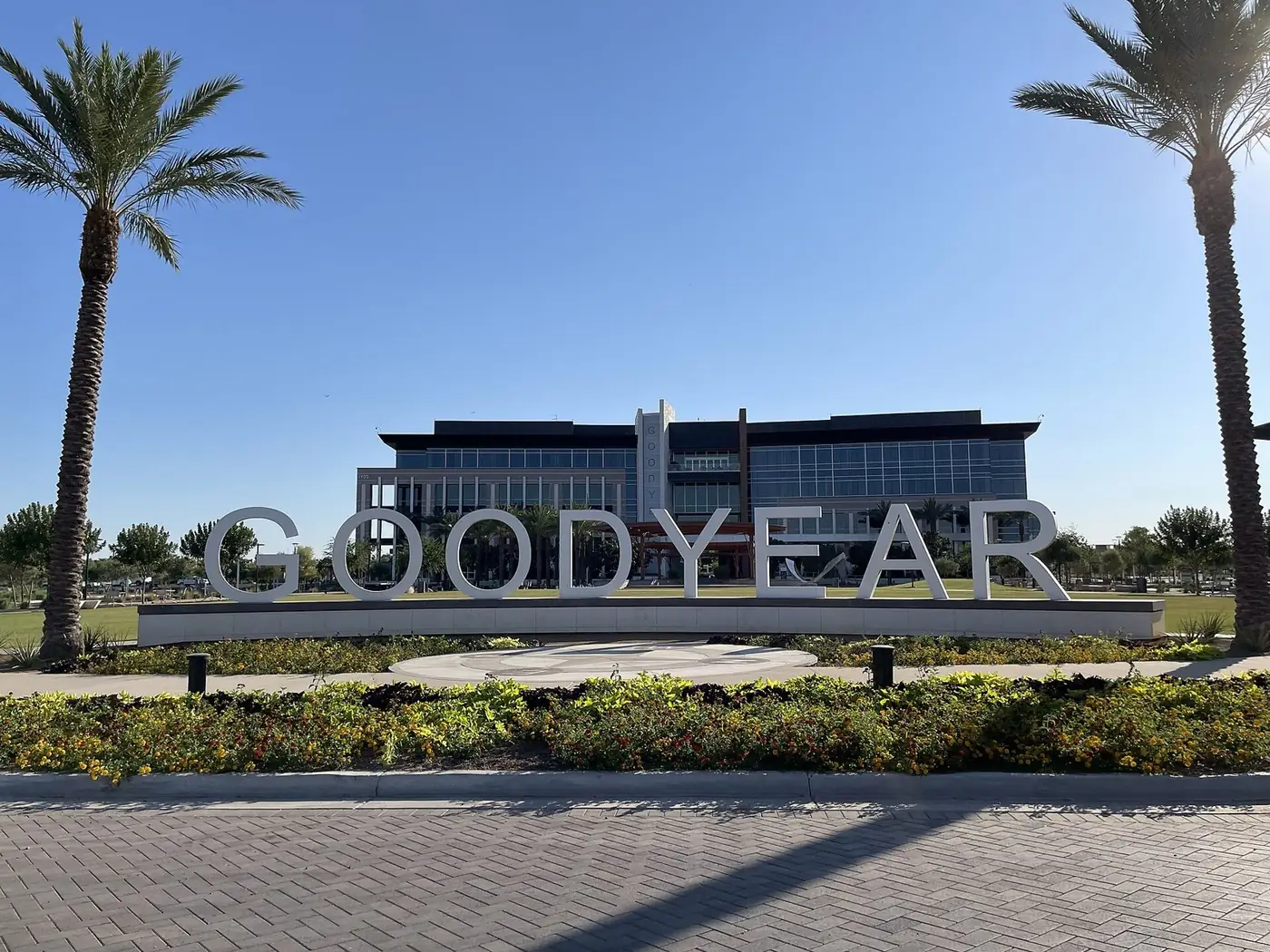 Goodyear city hall building behind a large GOODYEAR sign and palm trees