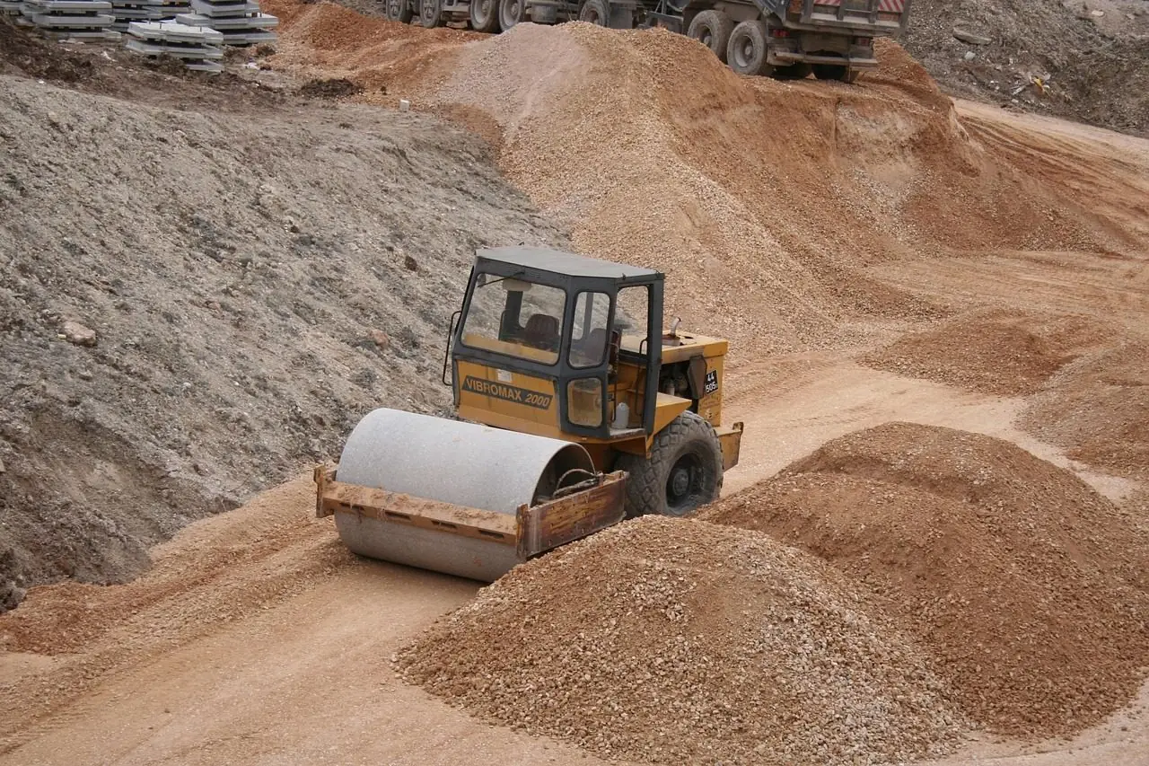 Small ride-on roller compacting sand and gravel
